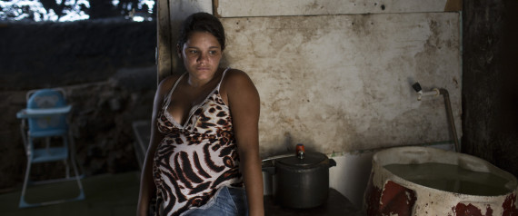 Leydiane da Silva, who's eight months pregnant, rests next to a water storage container, a potential mosquito breeding site, inside her home which stands on stilts above water, trash and sewage, in a slum in Recife, Pernambuco state, Brazil, Monday, Feb. 1, 2016. Zika is spread by the Aedes aegypti mosquito, which is well-adapted to humans, thrives in people's homes and can breed in even a bottle cap's-worth of stagnant water. While anyone can be bitten by Aedes, public health experts agree that the poor are more vulnerable because they often lack amenities that help diminish the risk, such as air conditioning and window screens. (AP Photo/Felipe Dana)