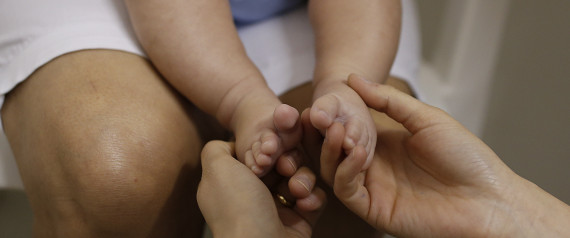 A health worker gives foot massage to 3-month-old Pedro Henrique in a hospital in Joao Pessoa, Brazil, Wednesday, Feb. 24, 2016, during an examination that's part of a study to determine if the Zika virus is causing babies to be born with a birth defect affecting the brain. Their goal is to persuade about 100 mothers of infants recently born with the defect as well to enroll in the study. They also need participation as controls of two to three times as many mothers from the same areas who delivered babies without microcephaly at about the same time. (AP Photo/Andre Penner)
